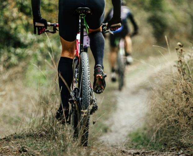 Ciclisti percorrono un sentiero sterrato in una gara di mountain bike.