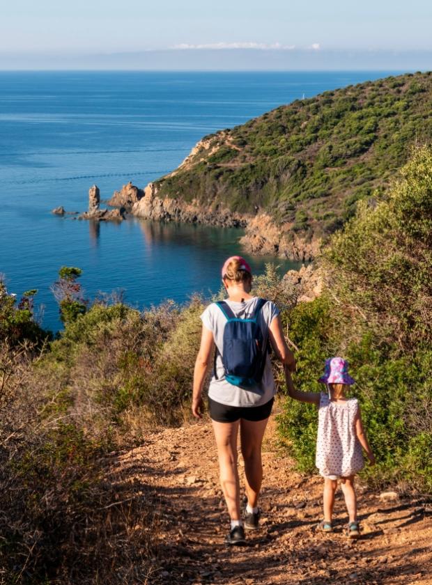 Passeggiata in famiglia lungo un sentiero costiero con vista sul mare.