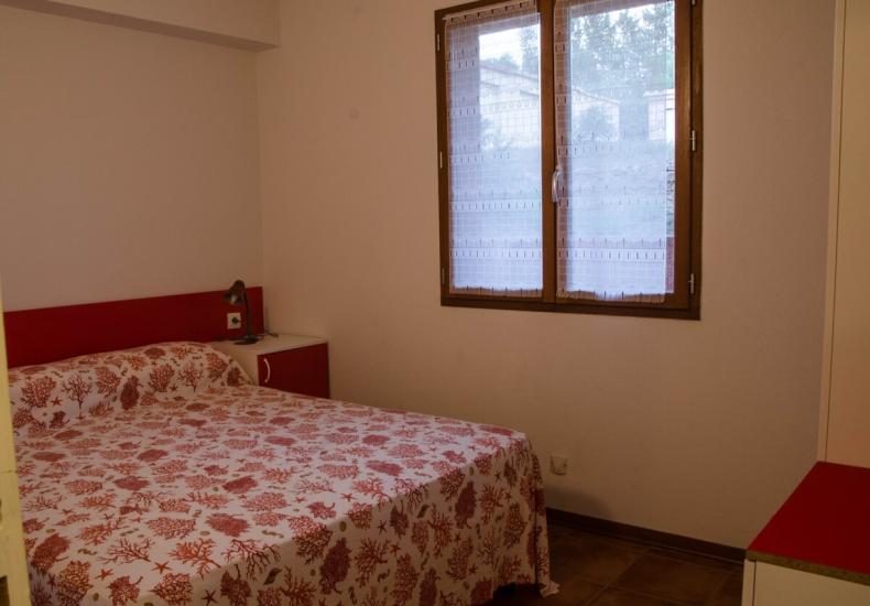 Camera da letto semplice con letto matrimoniale e finestra.