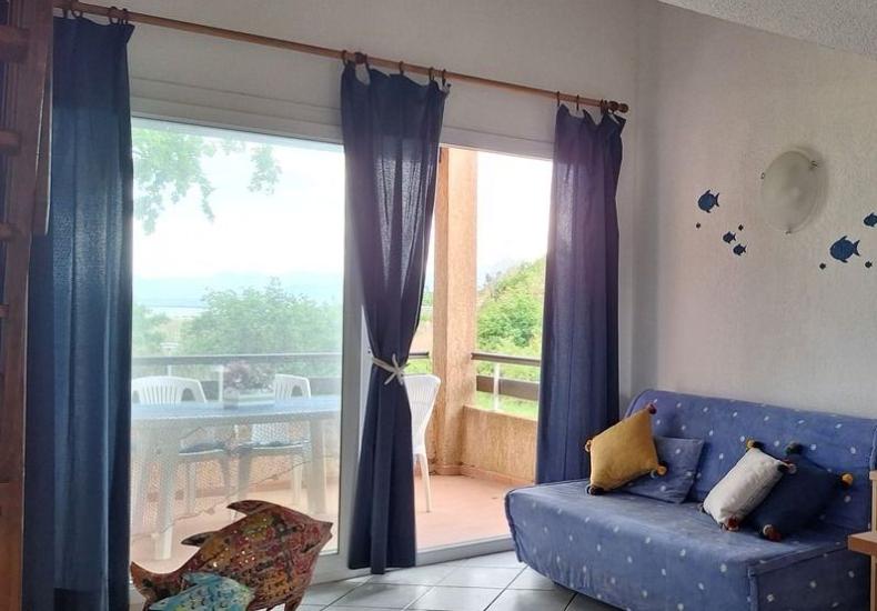 Soggiorno luminoso con divano blu e decorazioni marine.
