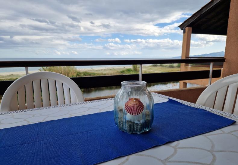 Terrazza con vista mare, tavolo e vaso decorativo.