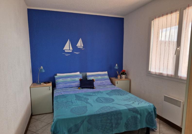 Camera da letto con tema marino e parete blu.